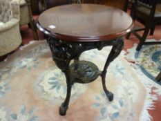 A COMMEMORATIVE BRITANNIA PUB TABLE with circular mahogany top and cast iron base, the under tier