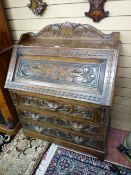 A LATE VICTORIAN CARVED FALL FRONT BUREAU with gallery top above a chamfered panel fall, the