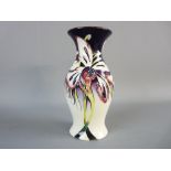 A MOORCROFT MODERN PATTERNED BALUSTER VASE with stylized floral decoration on a purple and cream