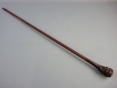 A MAHOGANY AND ROSEWOOD WALKING CANE, the brass tipped shaft with rope twist decoration and carved