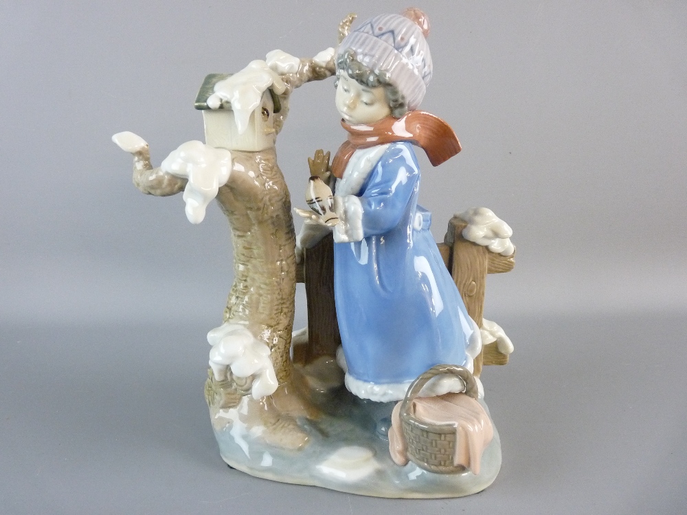A LLADRO FIGURE 'Winter Frost', a young girl with bird on hand standing by a birdhouse with snow