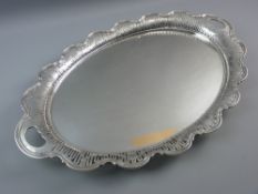 A GEORGE V SILVER TWO HANDLED SERVING TRAY having a shaped pierced border with floral swag