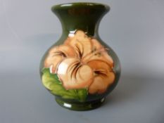 A MOORCROFT HIBISCUS BULBOUS VASE, 10 cms high, decorated on a green ground, impressed 'Moorcroft,