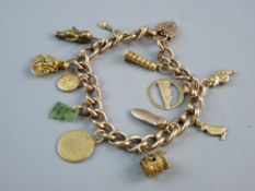 A NINE CARAT GOLD LINK CHARM BRACELET with approximately ten charms, padlock and safety chain, 27