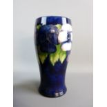 A MOORCROFT PANSY CYLINDRICAL VASE, cobalt blue ground, 24 cms high, 11.5 cms diameter with