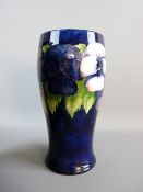 A MOORCROFT PANSY CYLINDRICAL VASE, cobalt blue ground, 24 cms high, 11.5 cms diameter with