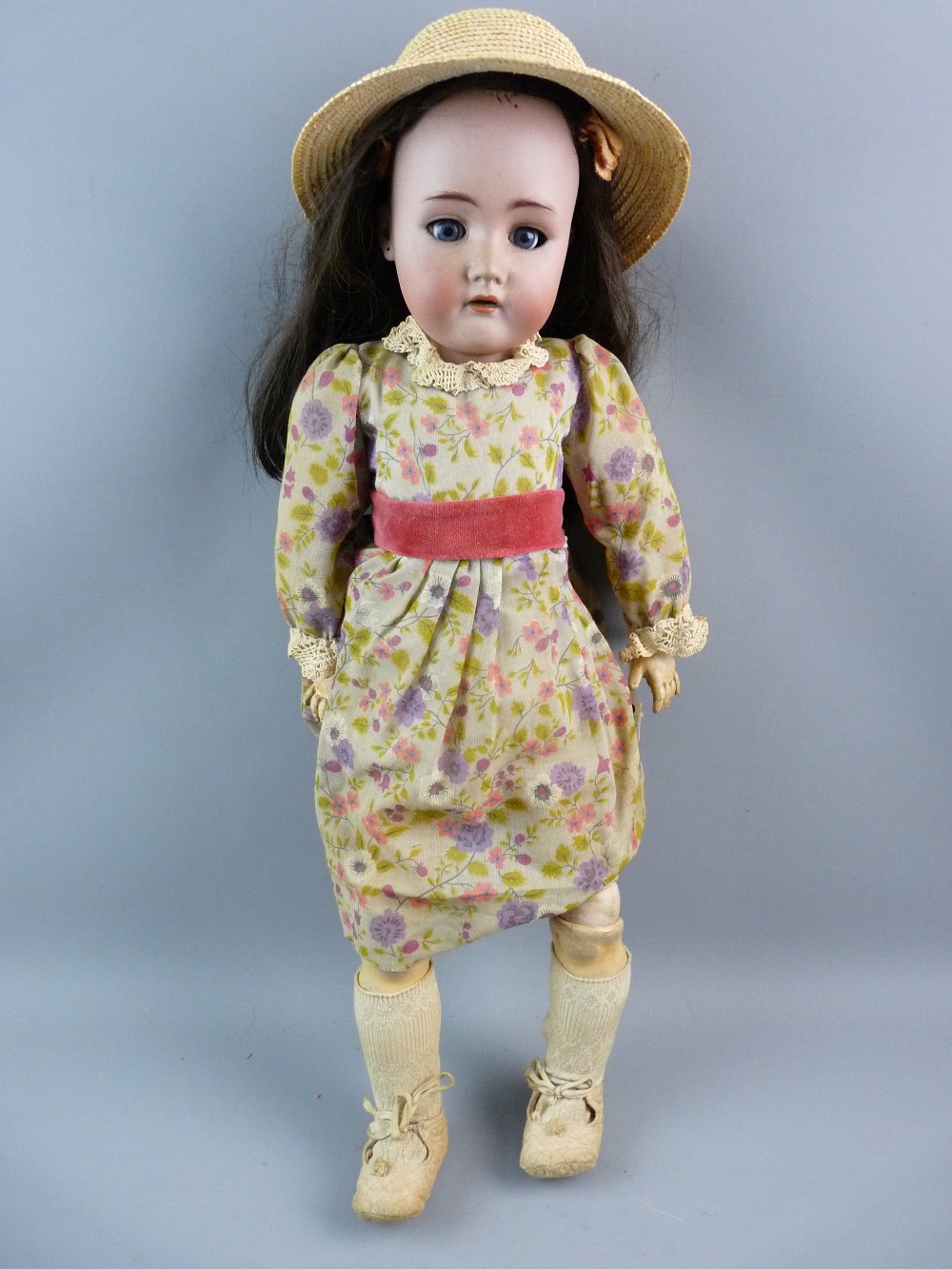 AN ANTIQUE BISQUE HEADED DOLL BY SIMON & HALBIG having a composition body and limbs with blue eyes