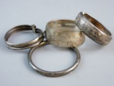 A PARCEL OF SILVER BANGLES comprising two wide half bright cut silver bangles and two hoop