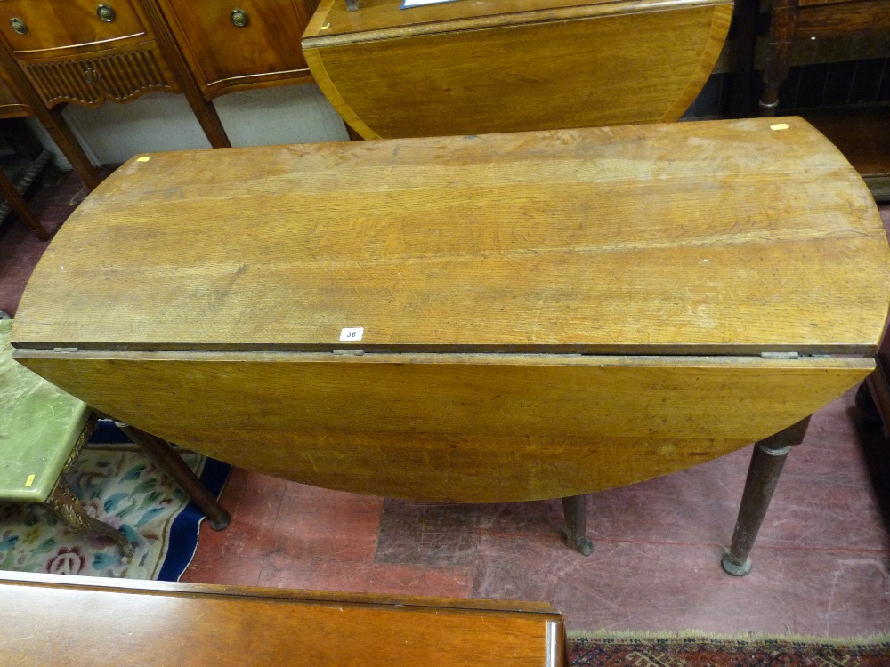 AN EARLY OAK TWIN FLAP DINING TABLE on six turned and block supports, the central two knuckle