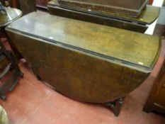 AN ANTIQUE OAK OVAL TOPPED GATE LEG DINING TABLE on barley twist and block supports with twist