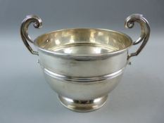 A HALLMARKED SILVER TWIN HANDLED BOWL with central rib to the body on a circular squat pedestal