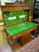 AN EDWARDIAN MAHOGANY TILE BACK WASHSTAND with carved shaped top rail, curved side shelves, flanking
