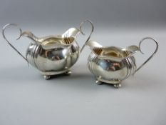 A HALLMARKED SILVER JUG AND SUGAR BOWL with bombe reed decorated bodies on bun feet, Birmingham