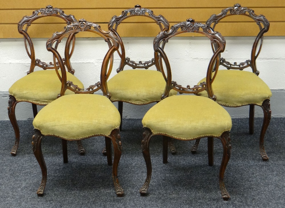 A SET OF FIVE CARVED BALLOON-BACK SALON CHAIRS in mahogany and having mustard coloured stuff-over