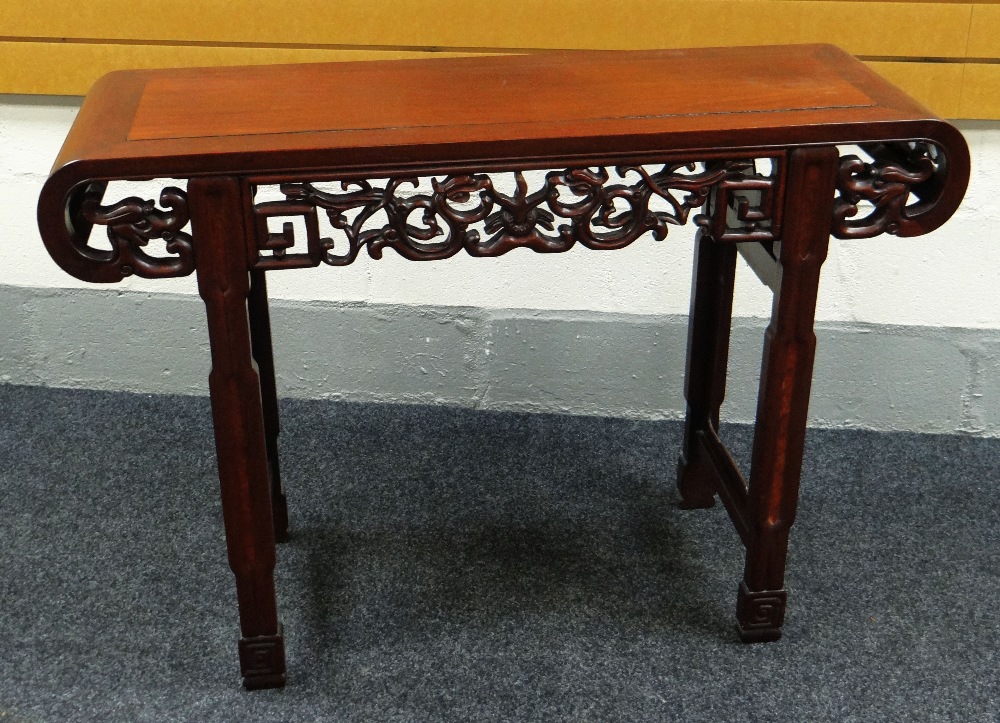 A CHINESE ROSEWOOD ALTAR TABLE having a fretwork frieze and rolled ends, 114cms wide