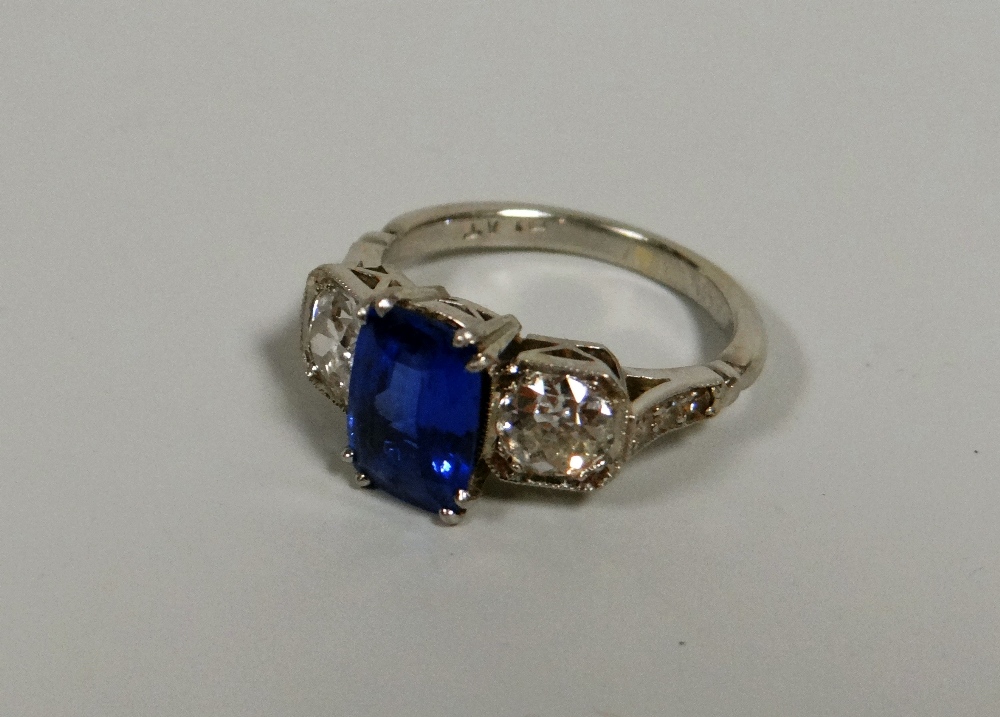 A SUPER PLATINUM, DIAMOND & SAPPHIRE RING with centre antique cut sapphire, 2.24cts flanked by two