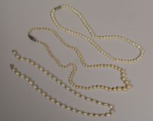 A SINGLE ROW OF GRADUATED PEARLS & A NECKLACE OF OVAL PEARLS and another