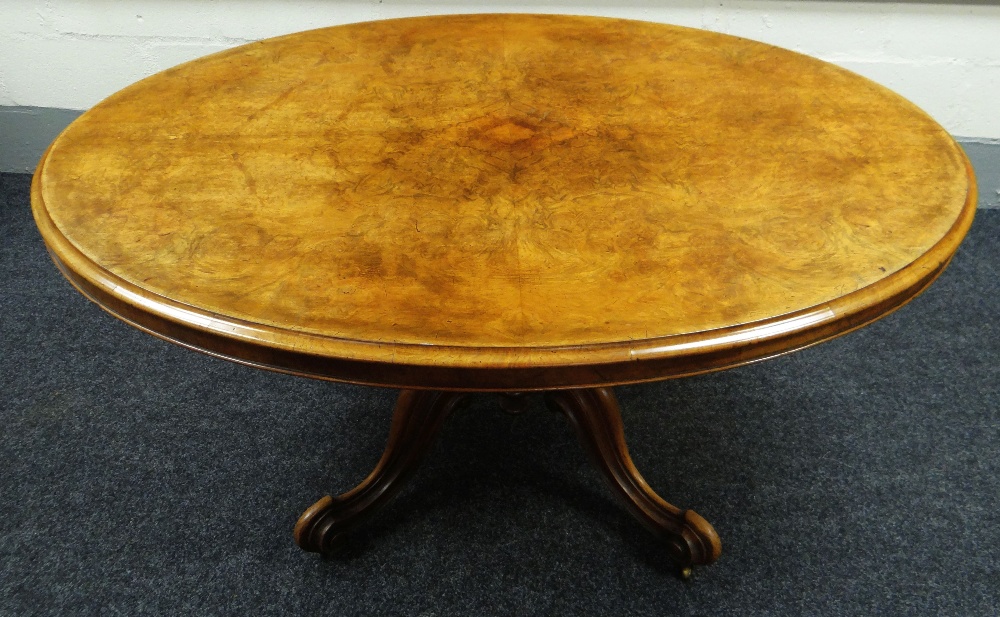 A VICTORIAN OVAL WALNUT BREAKFAST TABLE with tilt-top mechanism on four scroll supports, 58cms long