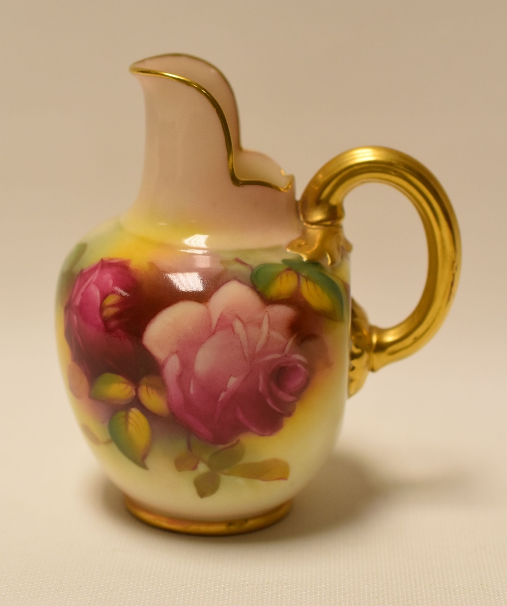 A SMALL ROYAL WORCESTER JUG with gilded handle and upright spout, painted with roses by Millie Hunt,