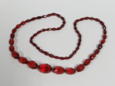 A FACETED CHERRY-RED AMBER BEAD NECKLACE, 47gms