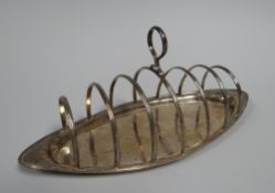 A GEORGE III SILVER TOAST-RACK of marquise form with ring handle and etched floral decoration,
