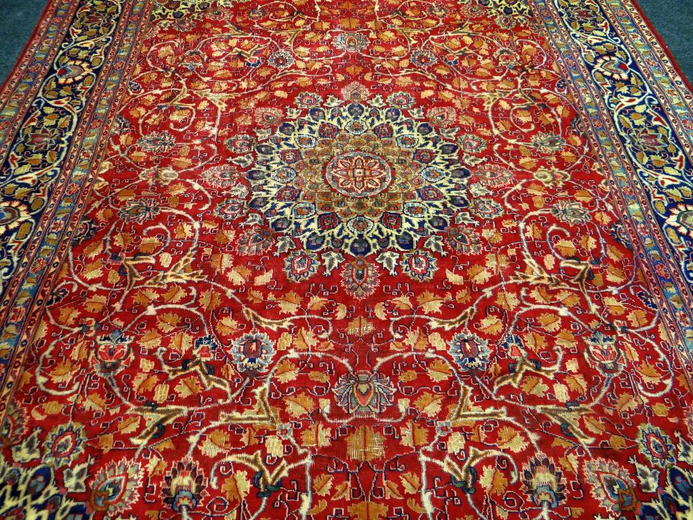 A LARGE OLD RED GROUND PERSIAN KASHAN CARPET with a shabaz medallion design, 388 x 294cms - Image 2 of 3