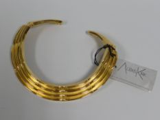 AN ALEXIS KIRK (1936-2010) DESIGNED YELLOW METAL TRIBAL-STYLE HINGING NECKLACE with label