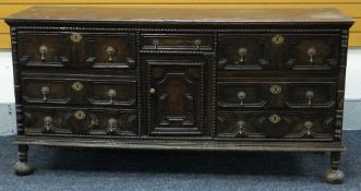 A JACOBEAN REVIVAL OAK SIDEBOARD with a centre single drawer and cupboard flanked by three drawers