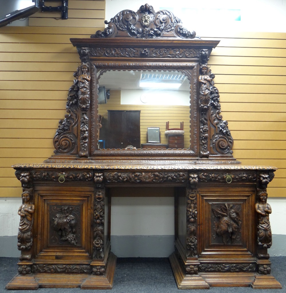 AN IMPOSING OAK MIRROR BACK PEDESTAL SIDEBOARD heavily and impressively carved all-round with