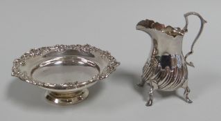A SILVER CREAM-JUG & SILVER DISH, the jug raised on four pad feet and with raised swirl decoration