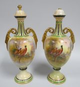 A PAIR OF CROWN DEVON 'GAME' PATTERN VASES with twin handles and of campana form, 36cms high (