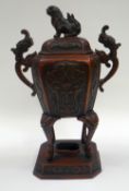 A CHINESE BRONZE CENSER of ovoid form with twin-handles and raised over an octagonal base, the lid