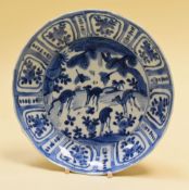 A BLUE & WHITE ORIENTAL DISH decorated with grazing deer and wildlife and with a floral border,