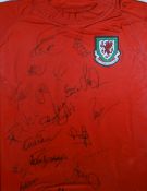 A FRAMED REPLICA WALES INTERNATIONAL FOOTBALL JERSEY signed by various former Wales International