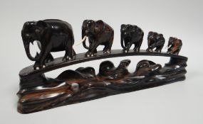 A HARDWOOD CARVED FAMILY TRAIN OF FIVE ELEPHANTS, 45cms long