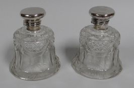A PAIR OF BELL SHAPED CUT-GLASS SCENT BOTTLES with hinged silver lids and stoppers