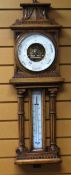 A LATE NINETEENTH CENTURY OAK ANEROID BAROMETER of architectural form and with carved detail,