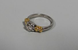 A PLATINUM & YELLOW GOLD DIAMOND SOLITAIRE RING, the diamond raised in a five claw setting, visual