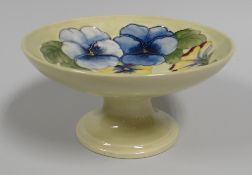A MOORCROFT PANSY TAZZA in yellow ground with a ring of blue and yellow flowers, 18cms diam