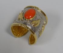 AN ALEXIS KIRK (1936-2010)TWO TONE TRIBAL STYLE BANGLE WITH RED JEWEL