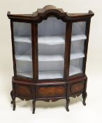 A MINIATURE MAHOGANY STANDING BIJOUTERIE CABINET having an arched glazed centre door flanked by