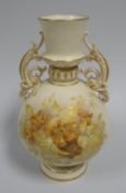 A ROYAL WORCESTER TWIN HANDLED VASE raised on a circular base, with tapered neck to the ovoid body