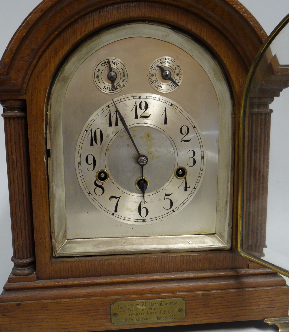 AN OAK ENCASED BRACKET-CLOCK having an arched silver dial with Arabic numberals and two subsidiary - Image 2 of 2