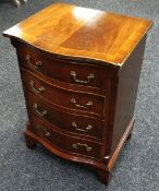 A REPRODUCTION SERPENTINE FRONT CHEST four graduated narrow drawers, 28cms wide