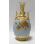 A ROYAL WORCESTER POWDER BLUE TWIN-HANDLED VASE decorated with gilded flowers and with yellow glazed