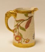 A ROYAL WORCESTER JUG WITH ELEPHANT HANDLE in blush ivory, gilding and with painted flowers, 13cms