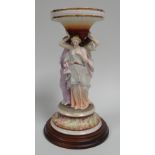 A MEISSEN PARIAN PORCELAIN COMPORT composed of three caryatid in pastel glazes standing on a