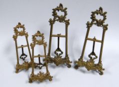 A SET OF 2+2 BRASS TABLE EASELS of fancy high-Victorian design