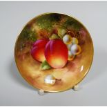 A SMALL ROYAL WORCESTER FRUIT PAINTED DISH of circular form and painted with peaches and green