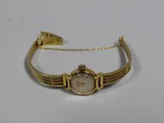 A 14K BWC GOLD LADIES WRISTWATCH with circular dial and flat bracelet, 21gms